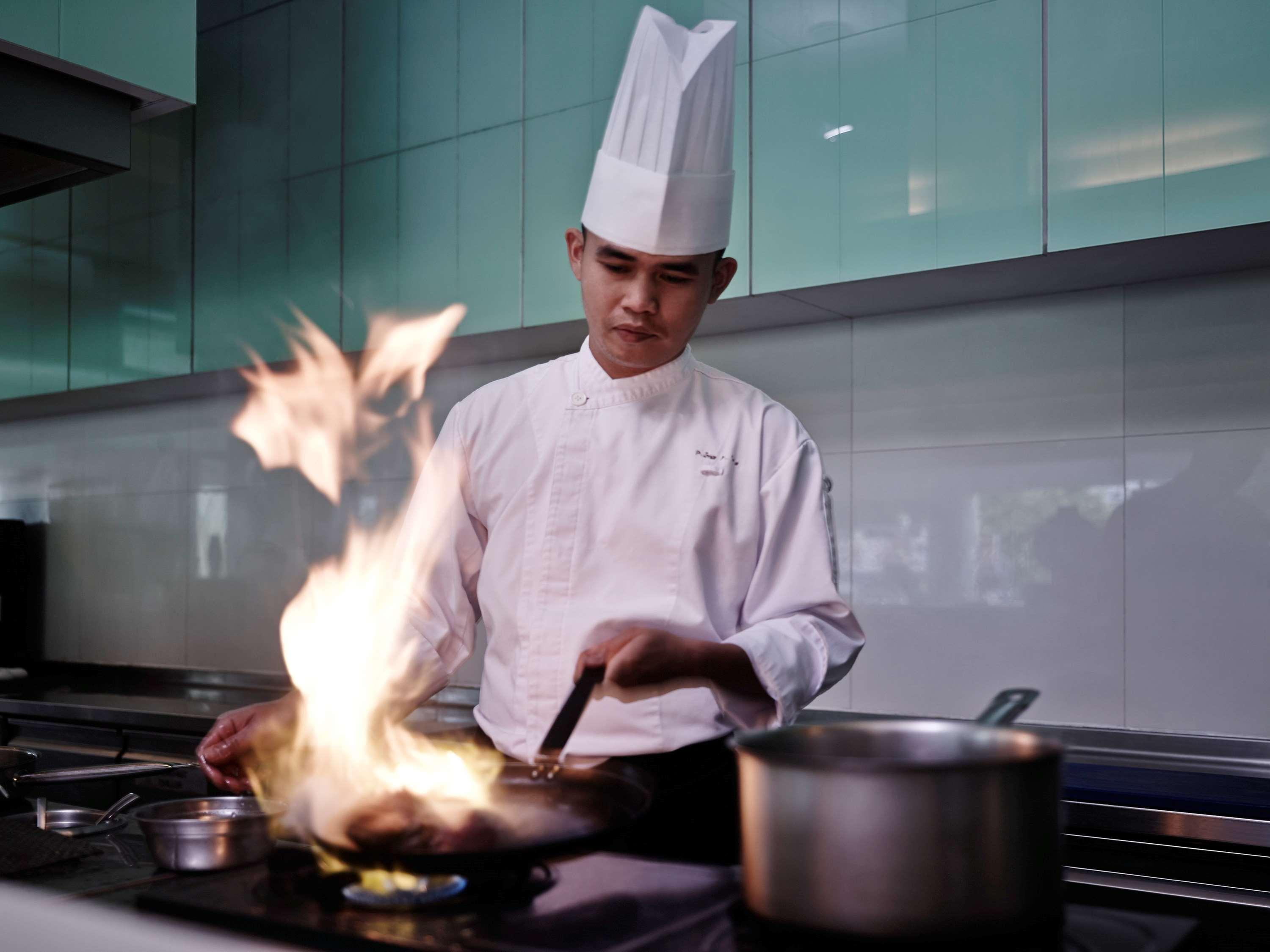 Готель Pullman Кучінг Екстер'єр фото A chef cooking with a flaming wok